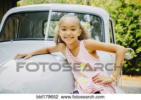 Mixed race girl leaning on car View Large Photo Image Stock Image - Mixed race girl leaning on car. Fotosearch