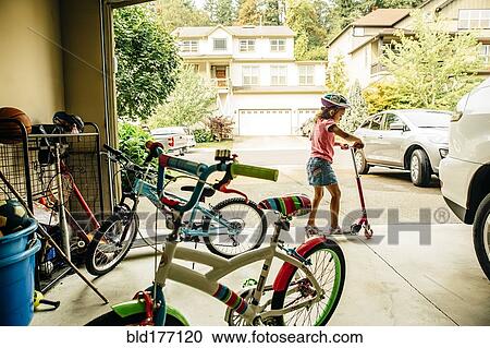 Stock Image - Mixed race girl playing with scooter. Fotosearch