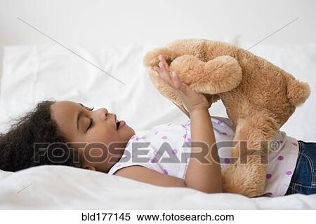 Mixed race girl playing with teddy bear View Large Photo Image Stock Photography - Mixed race girl playing with teddy bear. Fotosearch