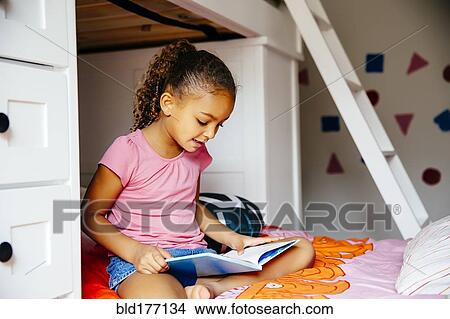 Mixed race girl reading on bed View Large Photo Image Picture - Mixed race girl reading on bed. Fotosearch