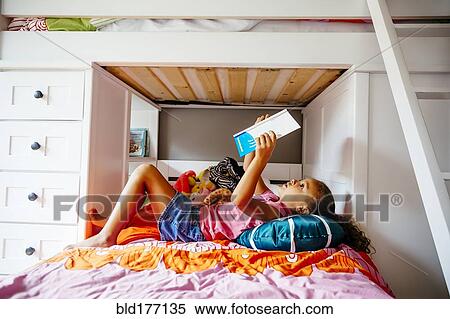 Mixed race girl reading on bed View Large Photo Image Stock Photography - Mixed race girl reading on bed. Fotosearch