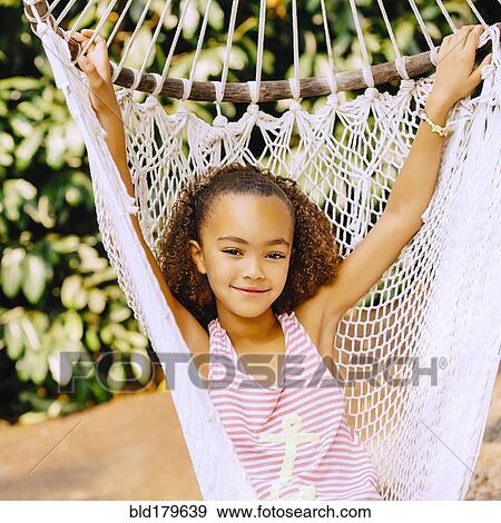 Stock Photo - Mixed race girl sitting in hammock. Fotosearch