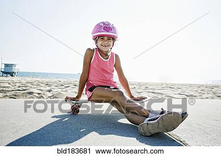 Mixed race girl sitting on skateboard at beach View Large Photo Image Stock Image - Mixed race girl sitting on skateboard at beach. Fotosearch