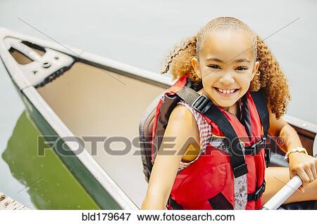 Mixed race girl smiling in canoe in lake View Large Photo Image Stock Photo - Mixed race girl smiling in canoe in lake. Fotosearch