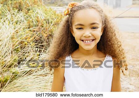 Mixed race girl smiling on beach View Large Photo Image Stock Image - Mixed race girl smiling on beach. Fotosearch