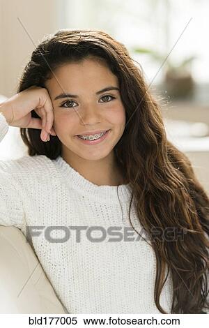 Mixed race girl smiling on sofa View Large Photo Image Stock Photography - Mixed race girl smiling on sofa. Fotosearch