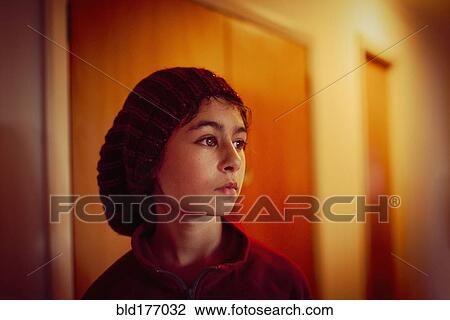 Stock Image - Mixed race girl standing in hallway. Fotosearch