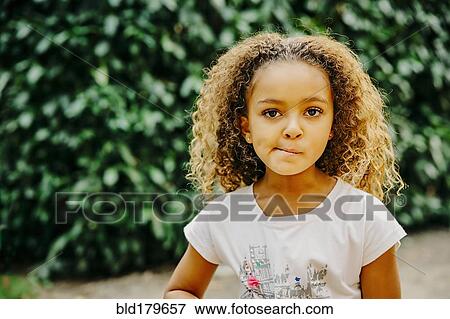 Stock Photo - Mixed race girl standing outdoors. Fotosearch