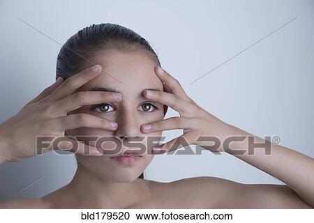 Stock Image - Mixed race girl touching her face. Fotosearch
