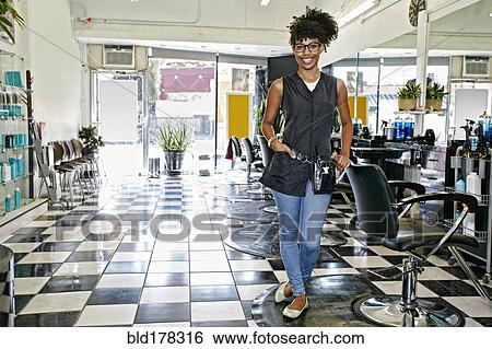 Stock Photograph - Mixed race hairstylist smiling in salon. Fotosearch