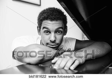 Mixed race man leaning on piano View Large Photo Image Stock Image - Mixed race man leaning on piano. Fotosearch
