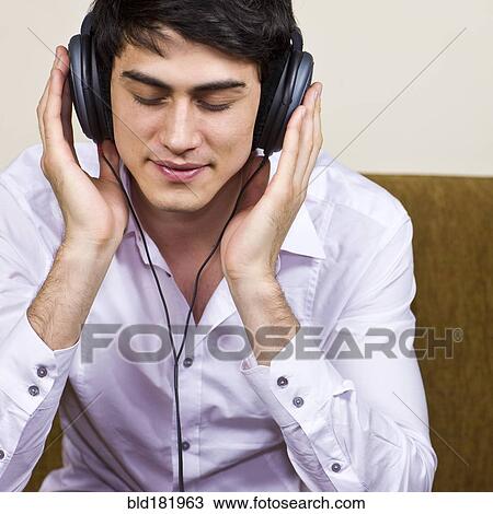 Mixed race man listening to headphones View Large Photo Image Stock Image - Mixed race man listening to headphones. Fotosearch