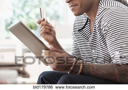 Mixed race man shopping online with digital tablet View Large Photo Image Stock Photograph - Mixed race man shopping online with digital tablet. Fotosearch