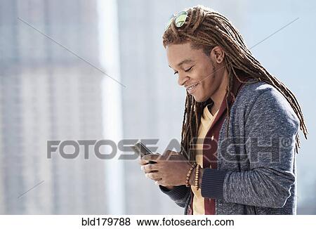Mixed race man using cell phone outdoors View Large Photo Image Stock Photo - Mixed race man using cell phone outdoors. Fotosearch