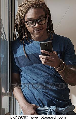 Stock Photo - Mixed race man using cell phone. Fotosearch