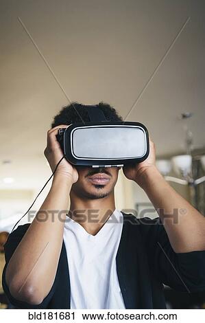 Mixed race man using virtual reality goggles View Large Photo Image Stock Image - Mixed race man using virtual reality goggles. Fotosearch