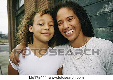 Mixed race mother and daughter hugging outdoors View Large Photo Image Picture - Mixed race mother and daughter hugging outdoors. Fotosearch
