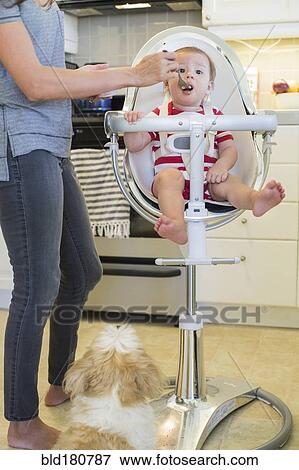 Stock Photo - Mixed race mother feeding baby outdoors. Fotosearch