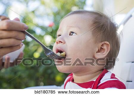 Mixed race mother feeding baby outdoors View Large Photo Image Stock Photography - Mixed race mother feeding baby outdoors. Fotosearch