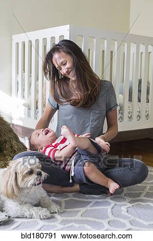 Mixed race mother playing with baby in nursery View Large Photo Image Stock Image - Mixed race mother playing with baby in nursery. Fotosearch