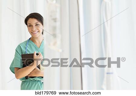 Stock Photo - Mixed race nurse smiling in hospital. Fotosearch