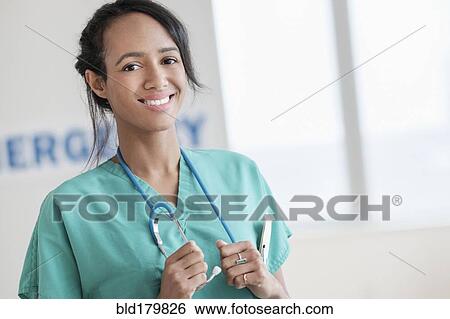 Mixed race nurse smiling in hospital View Large Photo Image Stock Photograph - Mixed race nurse smiling in hospital. Fotosearch