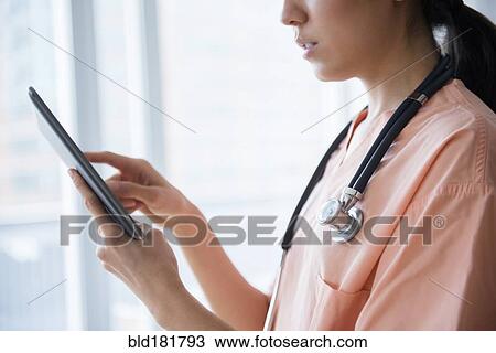 Mixed race nurse using digital tablet View Large Photo Image Stock Image - Mixed race nurse using digital tablet. Fotosearch