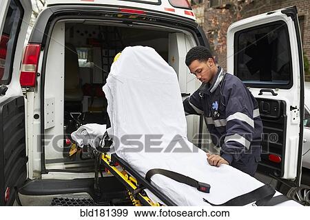 Mixed race paramedic rolling gurney from ambulance View Large Photo Image Stock Photo - Mixed race paramedic rolling gurney from ambulance. Fotosearch