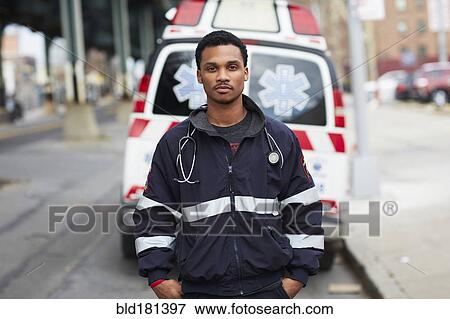 Mixed race paramedic standing near ambulance View Large Photo Image Stock Photo - Mixed race paramedic standing near ambulance. Fotosearch