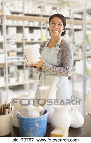 Mixed race potter smiling in workshop View Large Photo Image Stock Photo - Mixed race potter smiling in workshop. Fotosearch