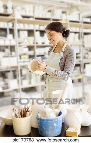 Mixed race potter working in workshop View Large Photo Image Stock Photo - Mixed race potter working in workshop. Fotosearch