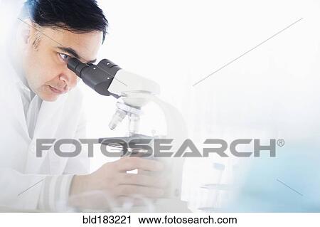 Stock Image - Mixed race scientist using microscope. Fotosearch