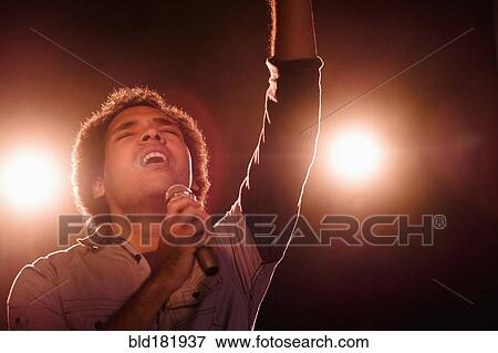 Stock Photo - Mixed race singer performing on stage. Fotosearch