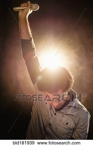 Stock Photo - Mixed race singer performing on stage. Fotosearch