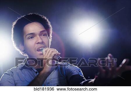 Stock Photograph - Mixed race singer performing on stage. Fotosearch