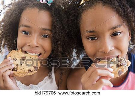 Mixed race sisters eating cookies View Large Photo Image Stock Photograph - Mixed race sisters eating cookies. Fotosearch