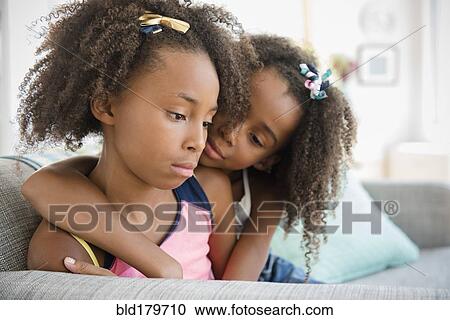Mixed race sisters hugging on sofa View Large Photo Image Stock Image - Mixed race sisters hugging on sofa. Fotosearch