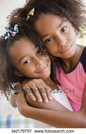 Mixed race sisters hugging View Large Photo Image Stock Photo - Mixed race sisters hugging. Fotosearch