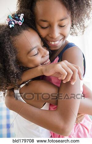 Mixed race sisters hugging View Large Photo Image Stock Photo - Mixed race sisters hugging. Fotosearch