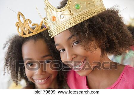 Stock Photo - Mixed race sisters playing dress up. Fotosearch