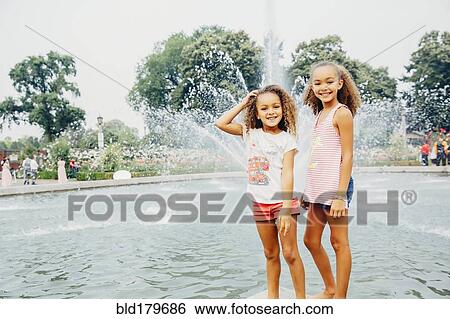 Mixed race sisters smiling in park View Large Photo Image Stock Photograph - Mixed race sisters smiling in park. Fotosearch