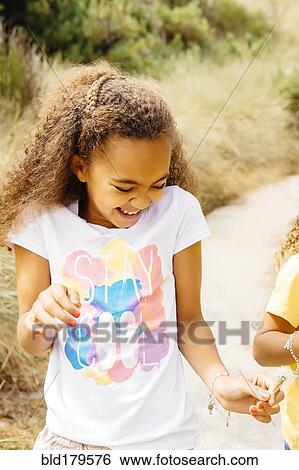 Mixed race sisters walking on dirt path View Large Photo Image Stock Photograph - Mixed race sisters walking on dirt path. Fotosearch