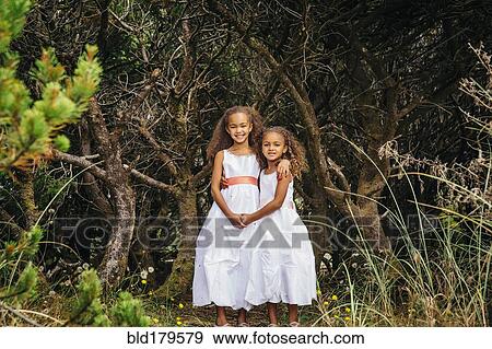 Mixed race sisters wearing dresses in garden View Large Photo Image Stock Photo - Mixed race sisters wearing dresses in garden. Fotosearch
