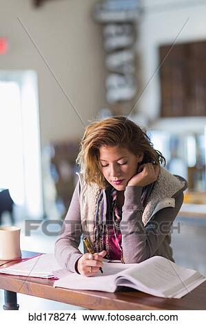 Picture - Mixed race student studying at table. Fotosearch