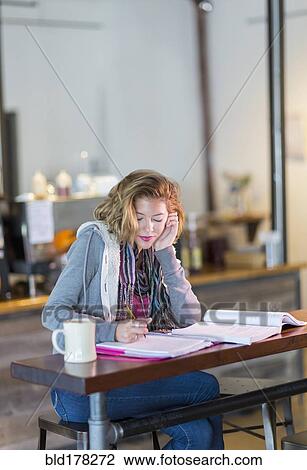 Stock Image - Mixed race student studying at table. Fotosearch