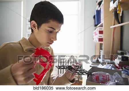 Stock Photography - Mixed race teenage boy building model toy. Fotosearch