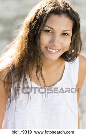 Stock Photo - Mixed race teenage girl smiling outdoors. Fotosearch