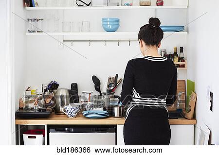 Stock Photograph - Mixed race woman cooking in kitchen. Fotosearch
