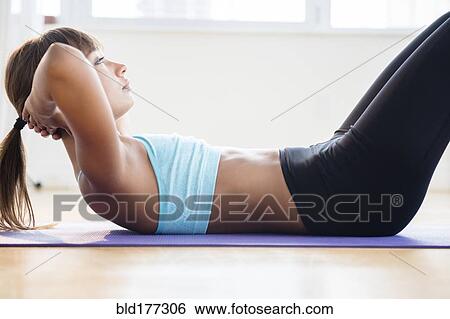 Mixed race woman doing sit-ups on yoga mat View Large Photo Image Stock Photograph - Mixed race woman doing sit-ups on yoga mat. Fotosearch