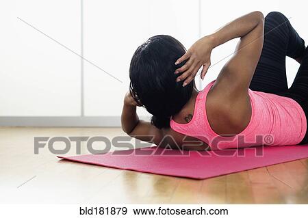Stock Photo - Mixed race woman doing sit-ups. Fotosearch